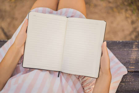 MOCKUP, SCENE CREATOR Women's hands in a tropical background holding a signboard, drawing block, paper, mockup.の写真素材
