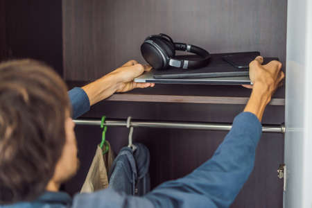 A man puts gadgets in a cabinet for digital detox
