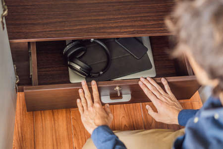 A man puts gadgets in a cabinet for digital detox
