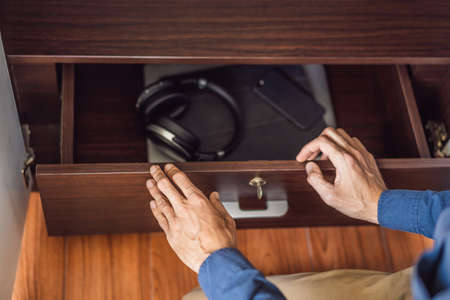 A man puts gadgets in a cabinet for digital detoxの写真素材