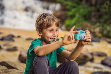 Little photographer taking picture with toy cameraの写真素材