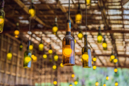 Beautiful retro light lamp decor made of empty wine bottles. Tonedの写真素材