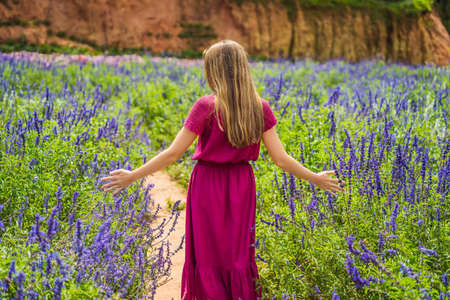 Beautiful woman relaxing in lavender field watching on sunset.