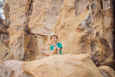 Young boy climbing on a rock, vacation conceptの写真素材