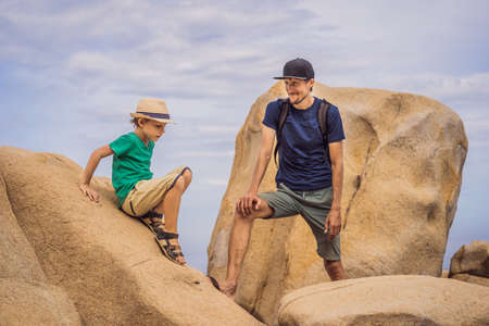 Dad and son on a rock. Domestic vacation concept