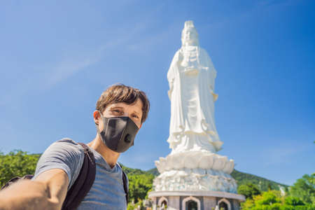 Male tourist in Da Nang, Vietnam wears a medical mask during a new wave of coronavirus in Vietnam due to illegal entry of Chineseの写真素材