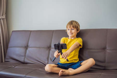 Staying connected. Happy young boy looking at his mobile phone and smiling while playing with toys....