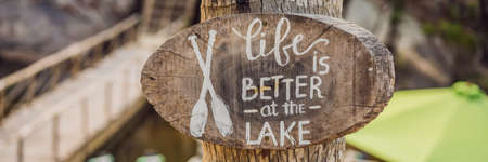Wooden board with a motivational phrase. Life better at the lake. Inspiration quote BANNER, LONG FORMATの写真素材