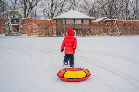 Child having fun on snow tube. Boy is riding a tubing. Winter fun for childrenの写真素材