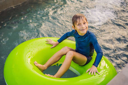 Little boy swimming with rubber ring at the leisure centerの写真素材