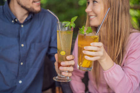 Eco friendly couple using reusable stainless steel straw to drink fruit teaの写真素材