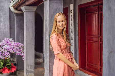 Woman tourist on background of Temple Ngoc Son in Hanoi, Vietnam.Temple of Literature is also called temple of Confucius. Vietnam reopens after coronavirus quarantine COVID 19の写真素材