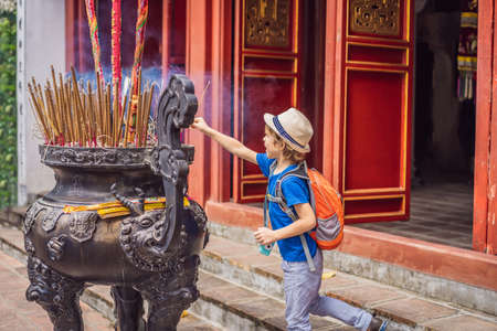 Incense sticks on joss stick pot are burning and smoke use for pay respect to the Buddha, Incense sticks in boy hand and smoke use for pray respect to the Buddha in Buddhism lifeの写真素材