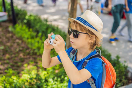 Little boy photographer tourist taking picture with toy camera