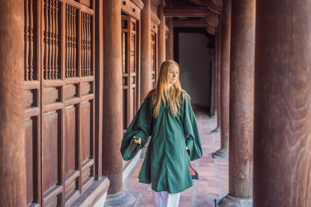 Woman tourist in national vietnamese dress in Temple of Literature in Hanoi in Southeast Asia, Vietnam. Vietnam reopens after coronavirus quarantine COVID 19の写真素材