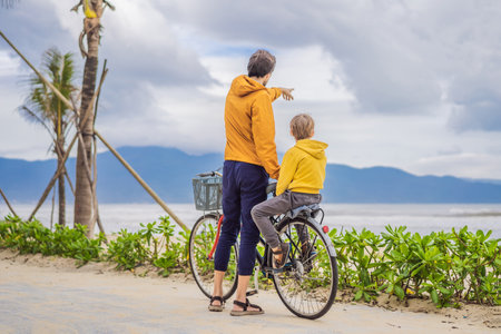Father with his son having a weekend excursion on bike on a summer day in beautiful landscapeの写真素材