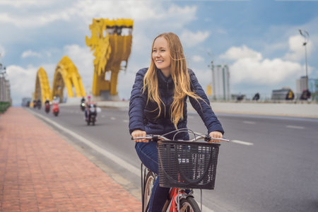 Woman rides a bicycle on the dragon bridge in Da Nangの写真素材