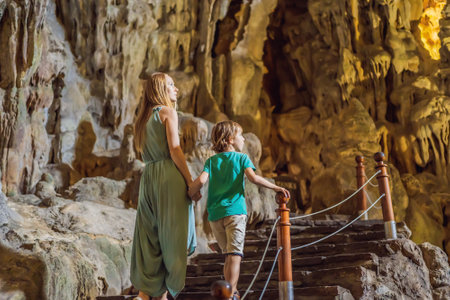 Mom and son tourists in Hang Sung Sot Grotto Cave of Surprises, Halong Bay, Vietnam. Traveling with children concept. Tourism after coronavirusの写真素材