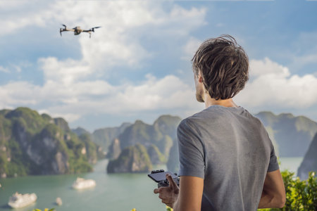 Man controls a drone in Halong Bay. Vietnam. Travel to Asia, happiness emotion, summer holiday concept. Picturesque sea landscape. Ha Long Bay, Vietnamの写真素材