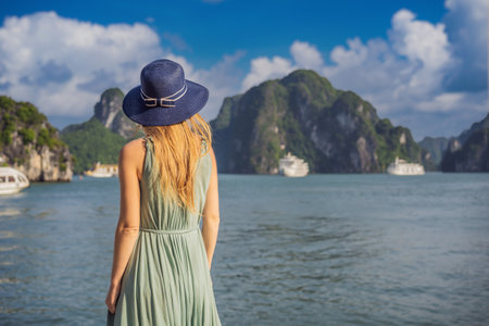 Attractive woman in a dress is traveling in Halong Bay. Vietnam. Travel to Asia, happiness emotion, summer holiday concept. Picturesque sea landscape. Ha Long Bay, Vietnamの写真素材