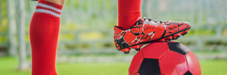 BANNER, LONG FORMAT Little cute kid boy in red football uniform playing soccer, football on field, outdoors. Active child making sports with kids or father, Smiling happy boy having fun in summerの写真素材