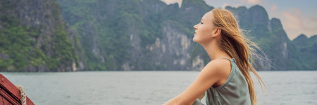 BANNER, LONG FORMAT Attractive woman in a dress is traveling by boat in Halong Bay. Vietnam. Travel to Asia, happiness emotion, summer holiday concept. Picturesque sea landscape. Ha Long Bay, Vietnamの写真素材