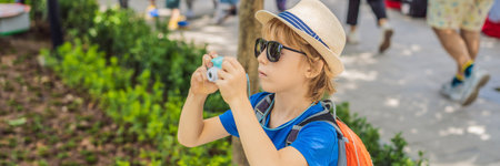 Little boy photographer tourist taking picture with toy camera BANNER, LONG FORMATの写真素材