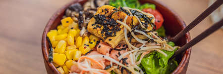 Raw Organic Poke Bowl with Rice and Veggies close-up on the table. Top view from above horizontal...