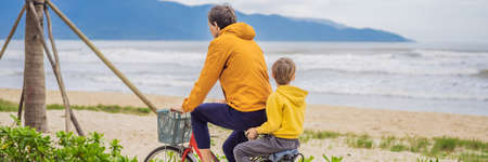 Father with his son having a weekend excursion on bike on a summer day in beautiful landscape BANNER, LONG FORMATの写真素材