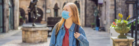 BANNER, LONG FORMAT Young woman wearing a medical mask during pandemic tourist walks down the street...