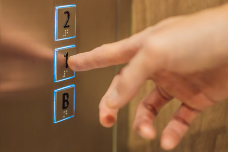 finger presses the number on the elevator button