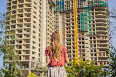 Woman at her new house under construction, planning future and dreaming. Real estate conceptの写真素材