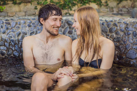 Couple at spa relaxing in round outdoor fragrant herbal bath, organic skin care, luxury spa hotel, lifestyle photoの写真素材