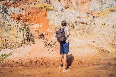 Man tourist on the Fairy stream among the red dunes, Muine, Vietnam. Vietnam opens borders after...