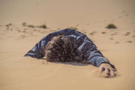 The person overcomes difficulties and aspires to the purpose and dream. A man overcomes difficulties in life as if in a desertの写真素材