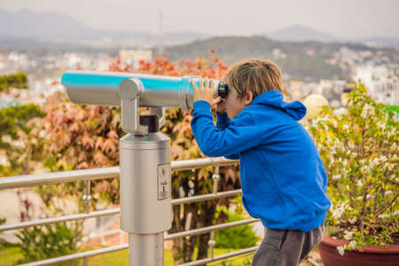 Binoscope. Stationary city binoculars. A boy looks at the city through a binoscope