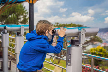 Binoscope. Stationary city binoculars. A boy looks at the city through a binoscopeの写真素材