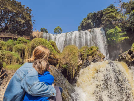 Mother and son tourists on the background of Elephant waterfall near Dalat city in Vietnamの写真素材