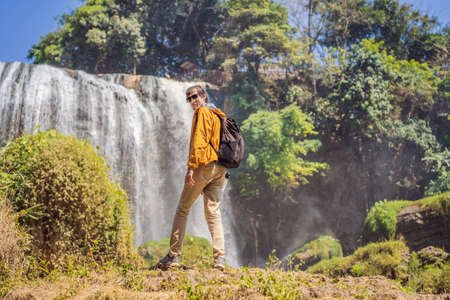 Male tourist on the background of Elephant waterfall near Dalat city in Vietnam