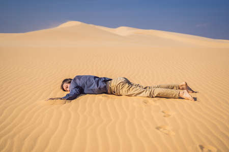 Exhausted man in the desert. Apathy, fatigue, exhaustion, mental disorders concept. Mental healthの写真素材