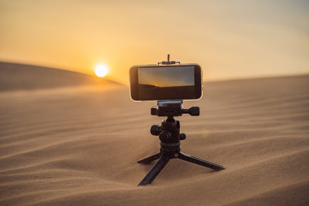 Photographing with smartphone. Travel concept. Sunset in the desert