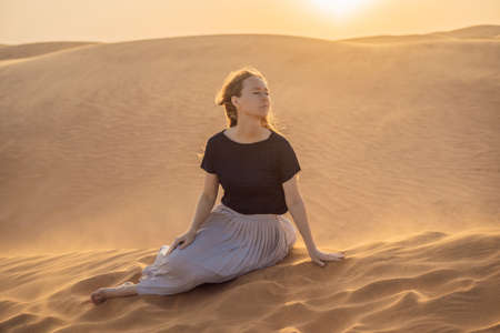 Young beautiful woman traveling in the desert. Sandy dunes and blue sky on sunny summer day. Travel,...