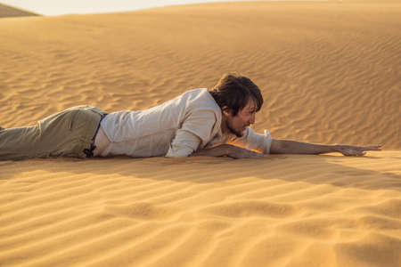 The person overcomes difficulties and aspires to the purpose and dream. A man overcomes difficulties in life as if in a desertの写真素材