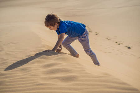 Boy overcomes difficulties and aspires to the purpose and dream. Boy overcomes difficulties in life as if in a desertの写真素材