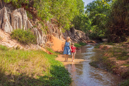 Mom and son tourists on the Fairy stream among the red dunes, Muine, Vietnam. Vietnam opens borders after quarantineの写真素材