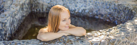 BANNER, LONG FORMAT Woman relaxing in round outdoor fragrant herbal bath, organic skin care, luxury...