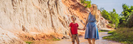 Mom and son tourists on the Fairy stream among the red dunes, Muine, Vietnam.