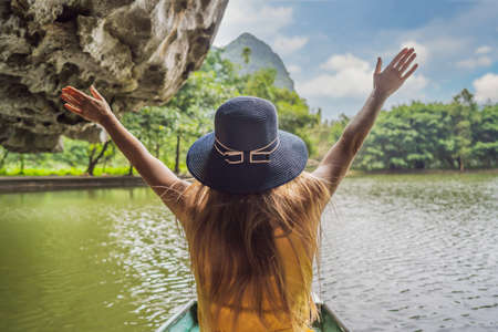 Woman tourist in boat on the lake Tam Coc, Ninh Binh, Viet nam.の写真素材