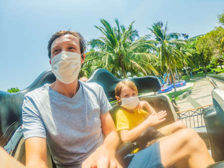 Family wearing a medical mask during COVID-19 coronavirus at an amusement parkの写真素材