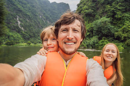 Happy family tourists in Trang An Scenic Landscape Complex in Ninh Binh Province, Vietnamの写真素材